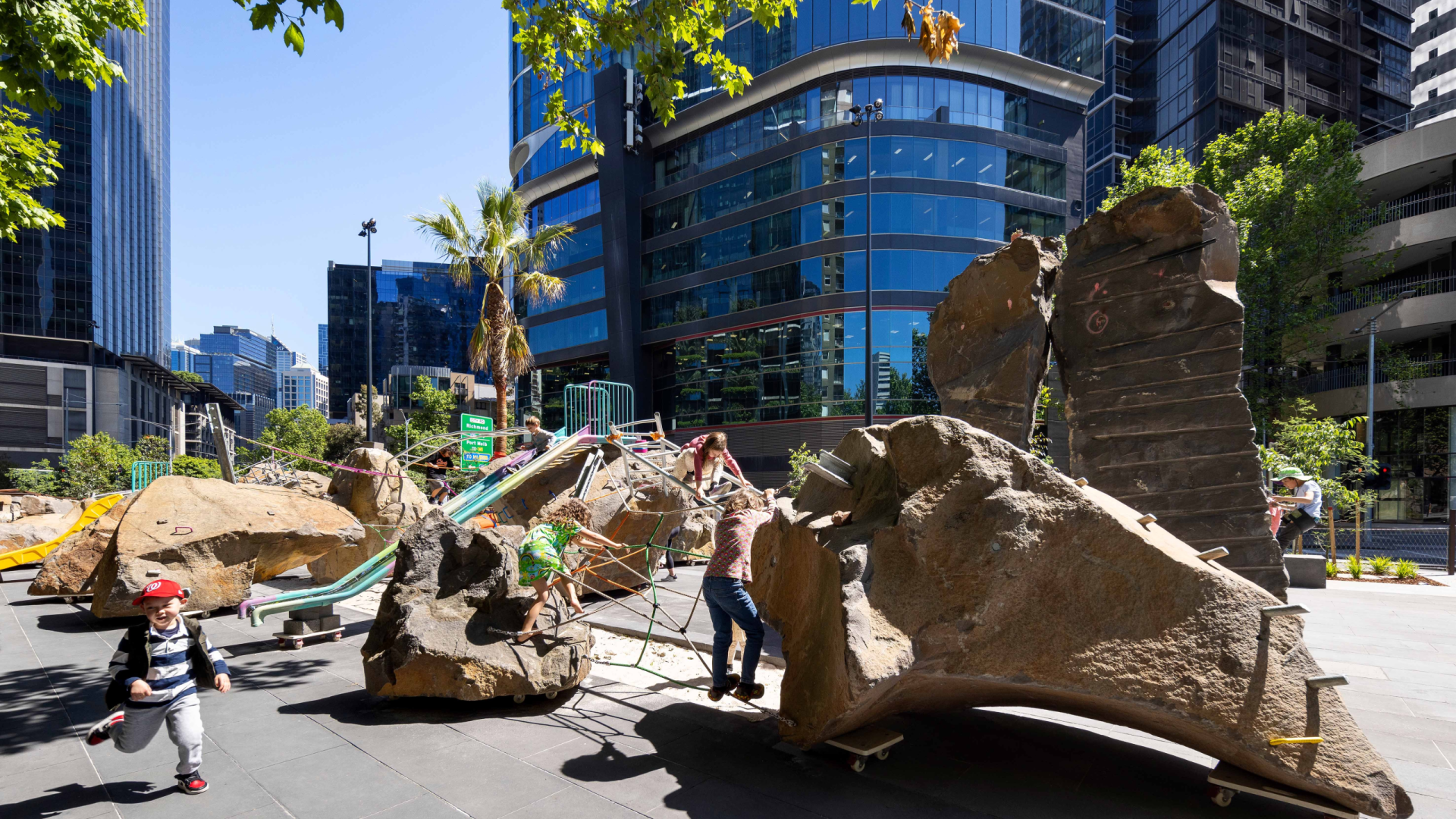 Photo of Southbank playspace featuring children playing on and amongst large bluestone boulders